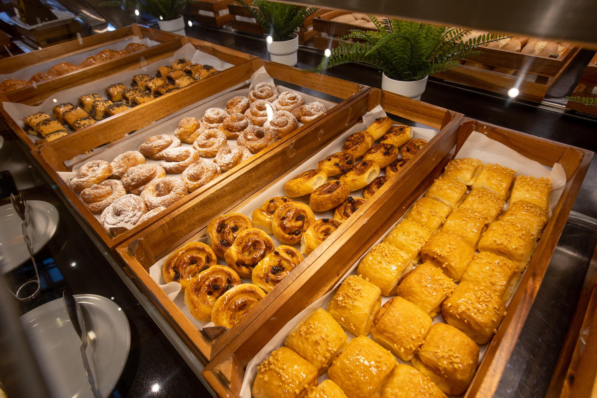 Wooden trays with ensaimadas, croissants and napolitanas.